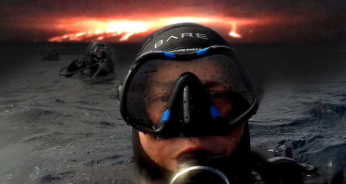Diver in water with volcano behind him