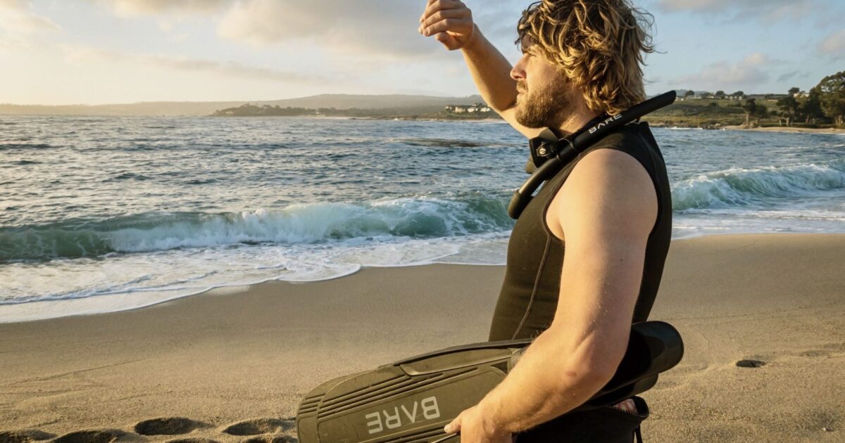 man looking into ocean from beach